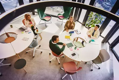 Bird view of people sitting at a round table and having a meeting