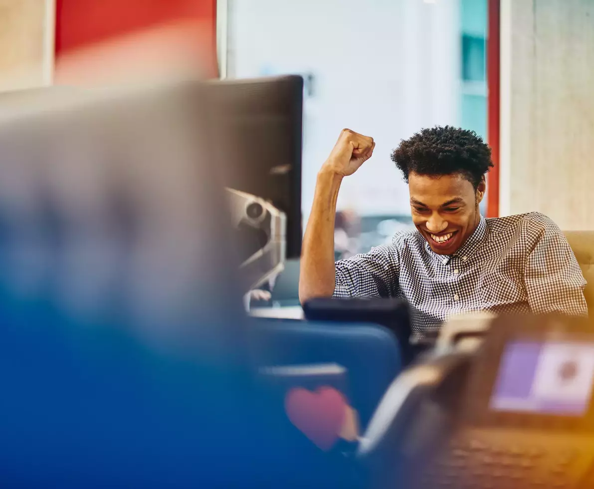 Male cheering at his desk 