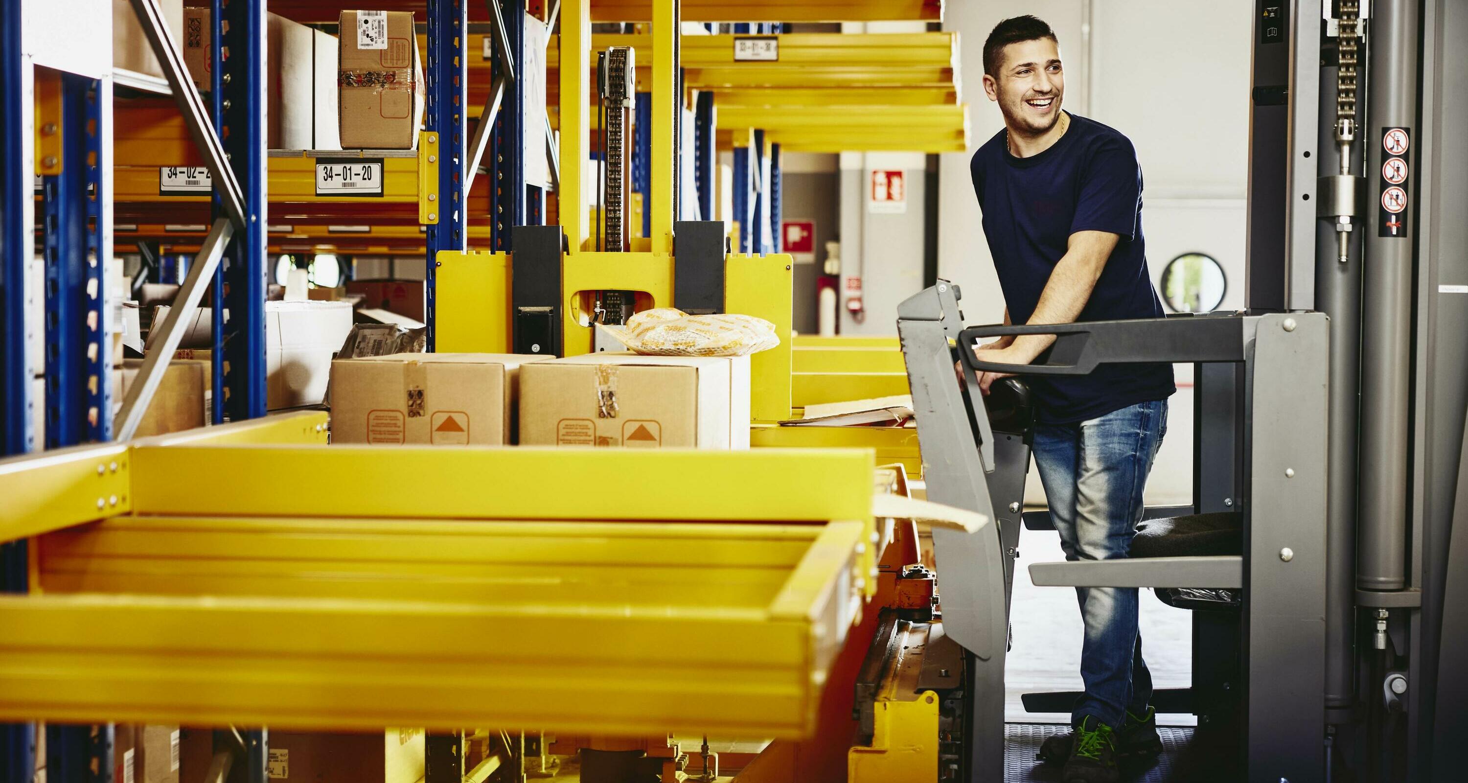 Smiling male standing on a forklift. Smiling male standing on a forklift.